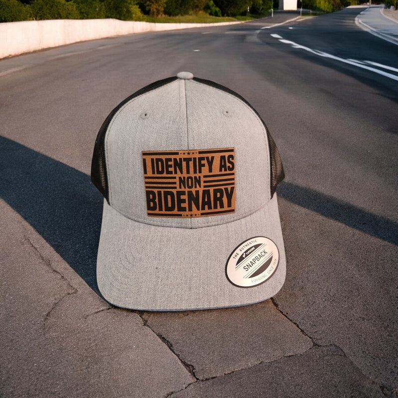 I Identify as Non-Bidenary Leather Patch Trucker Hat Heather Grey/Black